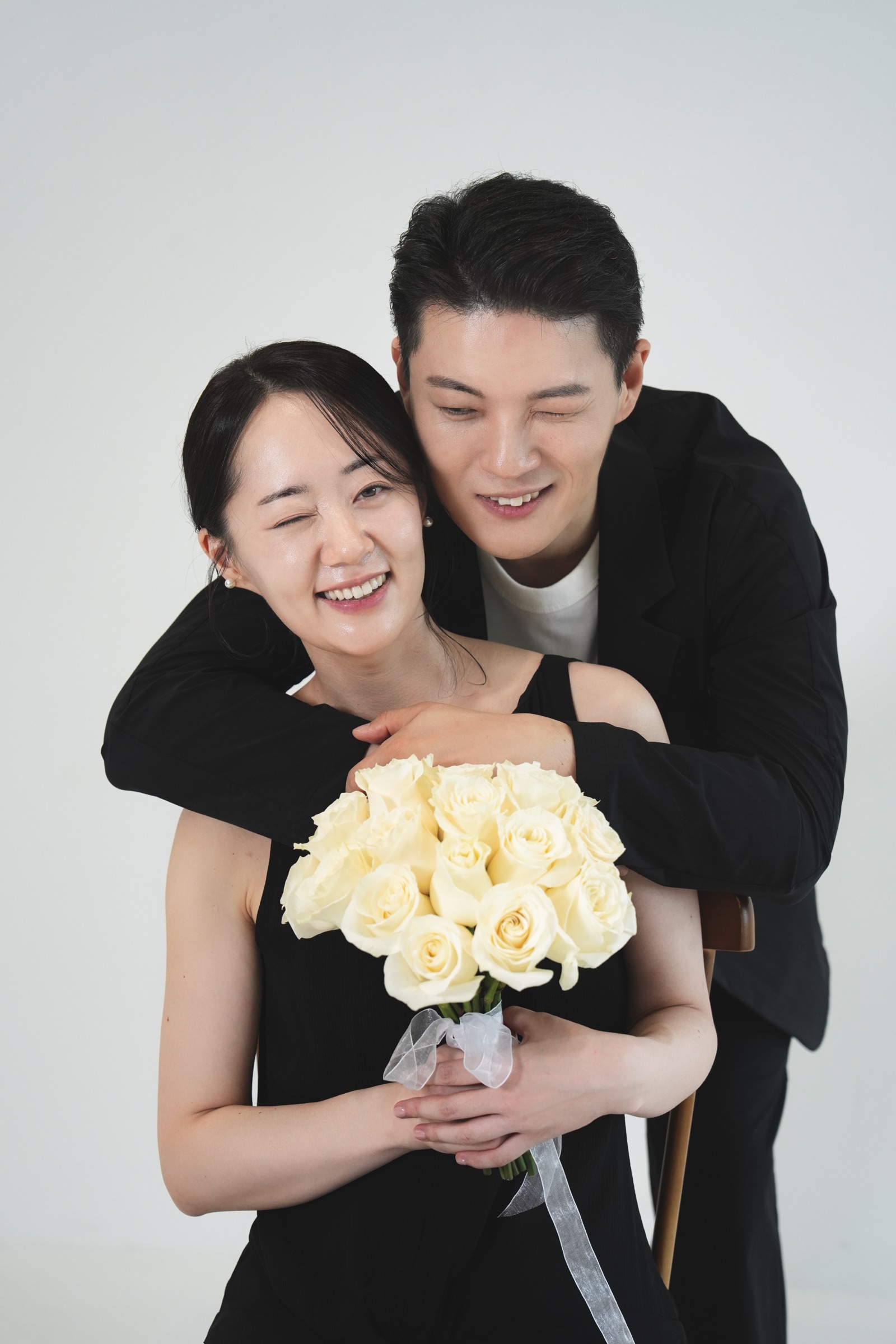 꽃다발을 든 유도영을 뒤에서 안고 웃는 김필중